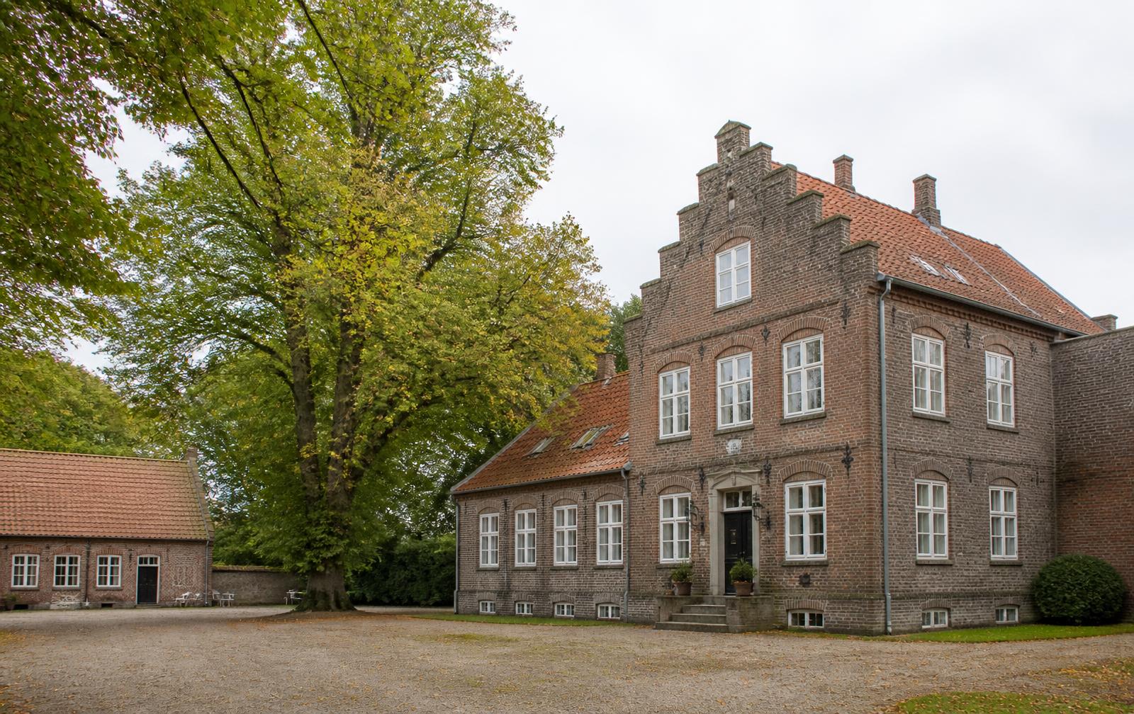Norddeutscher Gutshof aus Backstein mit Kieshof und alten Bäumen
